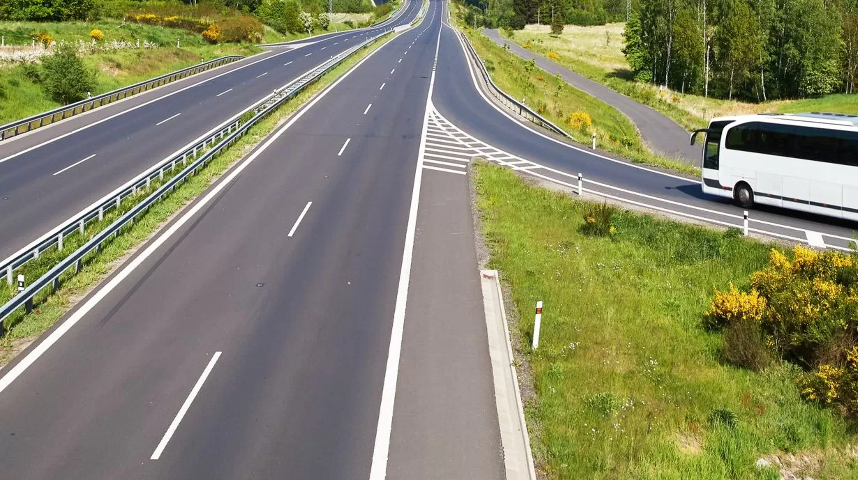 White coach entering an empty motorway